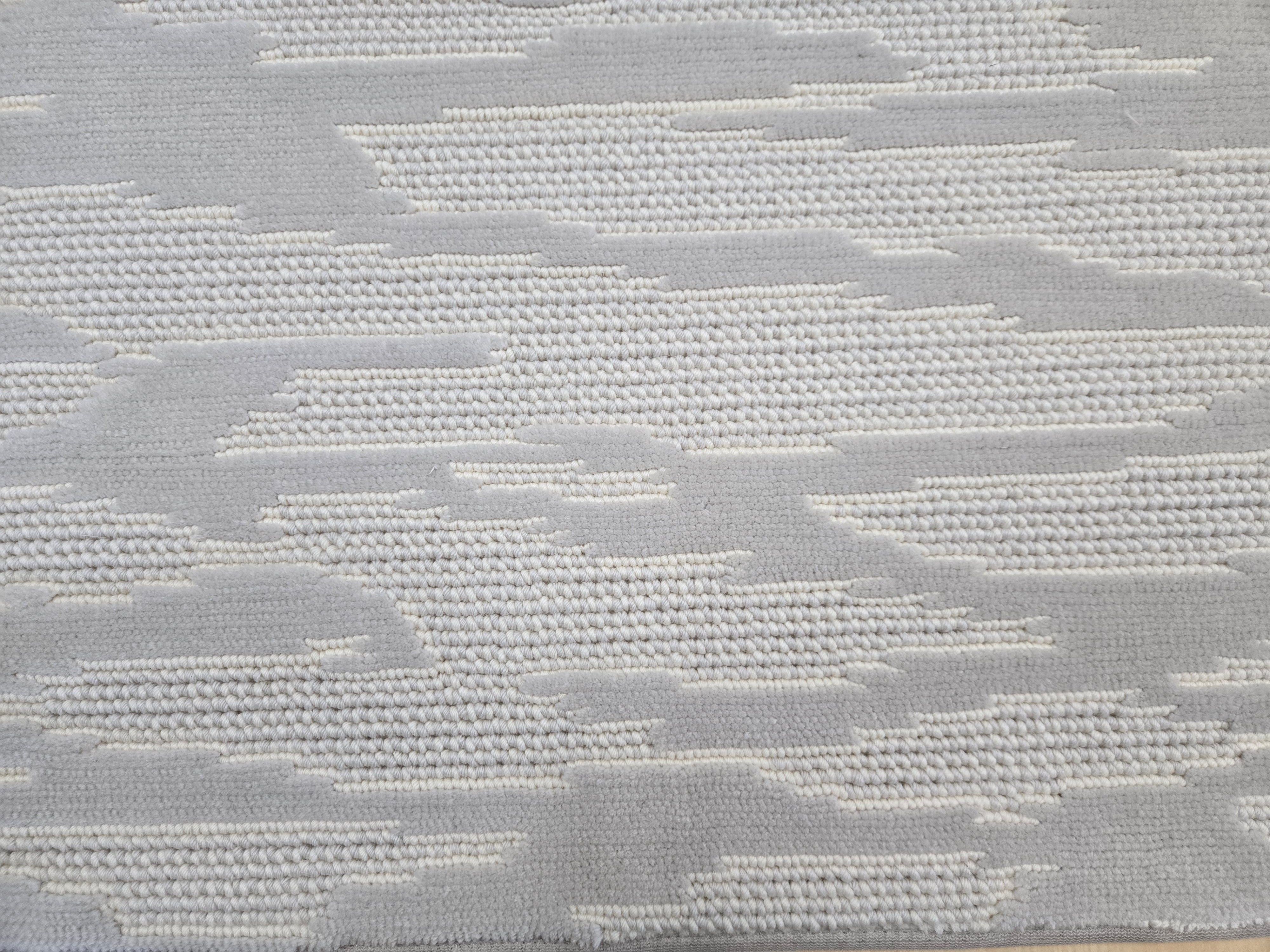 Broadloom carpet detail in an abstract cloud design in ivory and light grey.