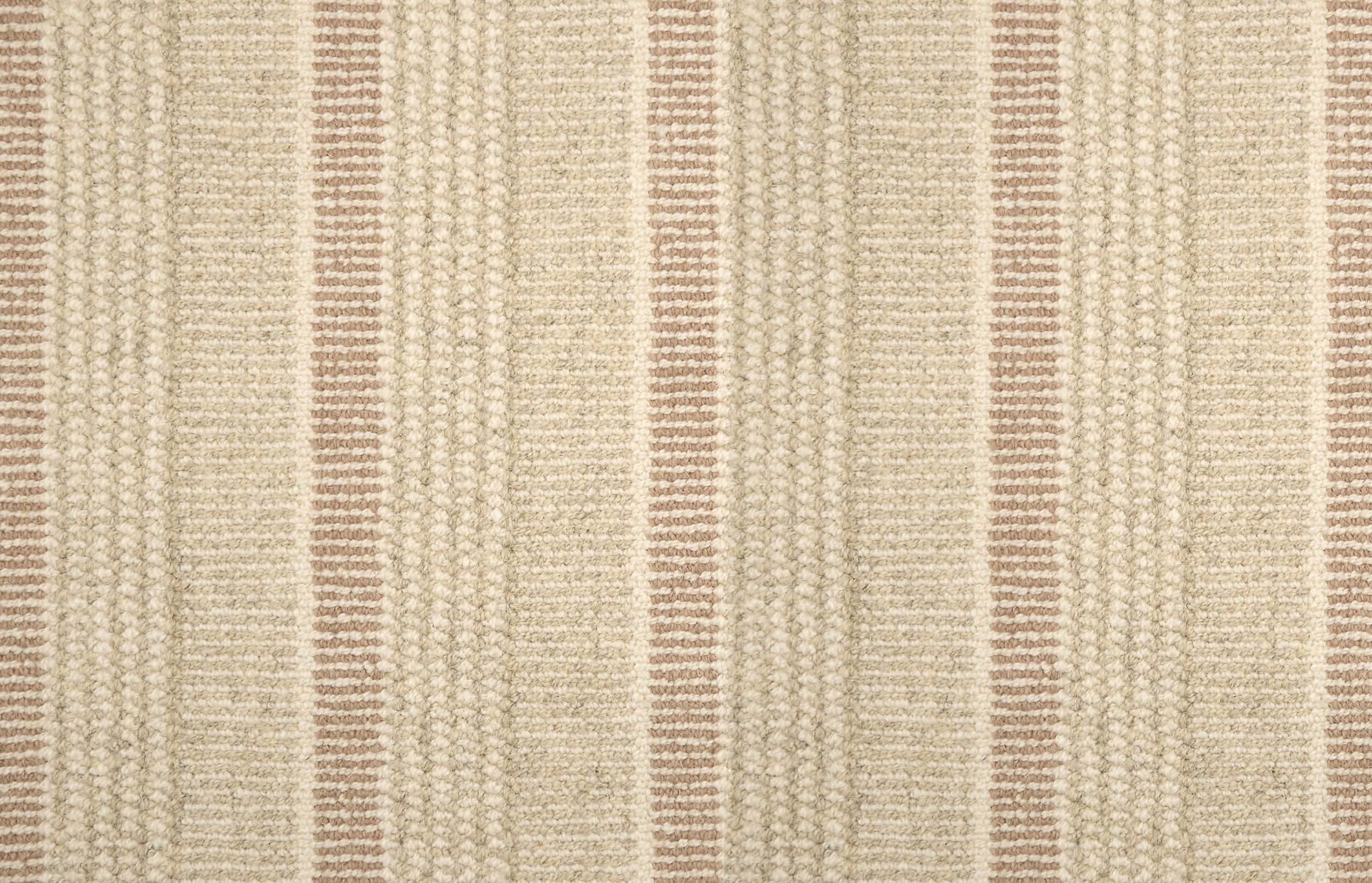 Textured broadloom carpet in beige with stripes in clay pink.