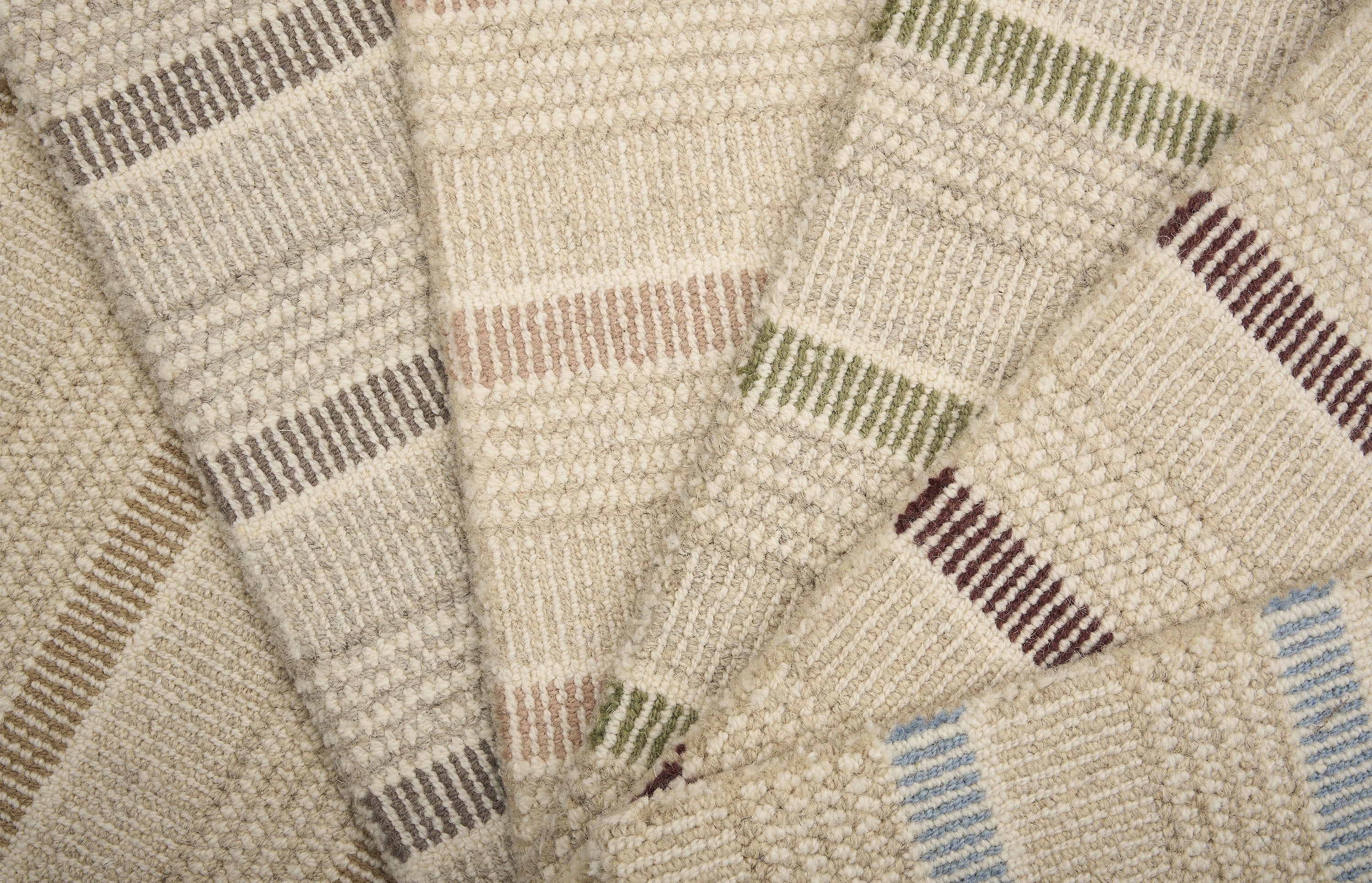A spread of striped broadloom samples in various colors. 