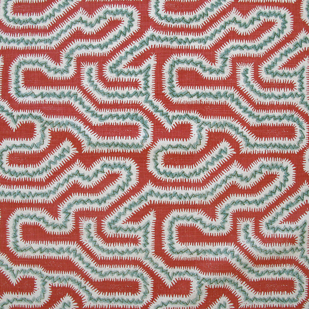 Detail of fabric in a dense meandering print in white, turquoise and gray on a red field.