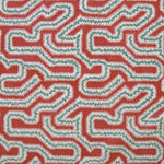 Detail of fabric in a dense meandering print in white, turquoise and gray on a red field.