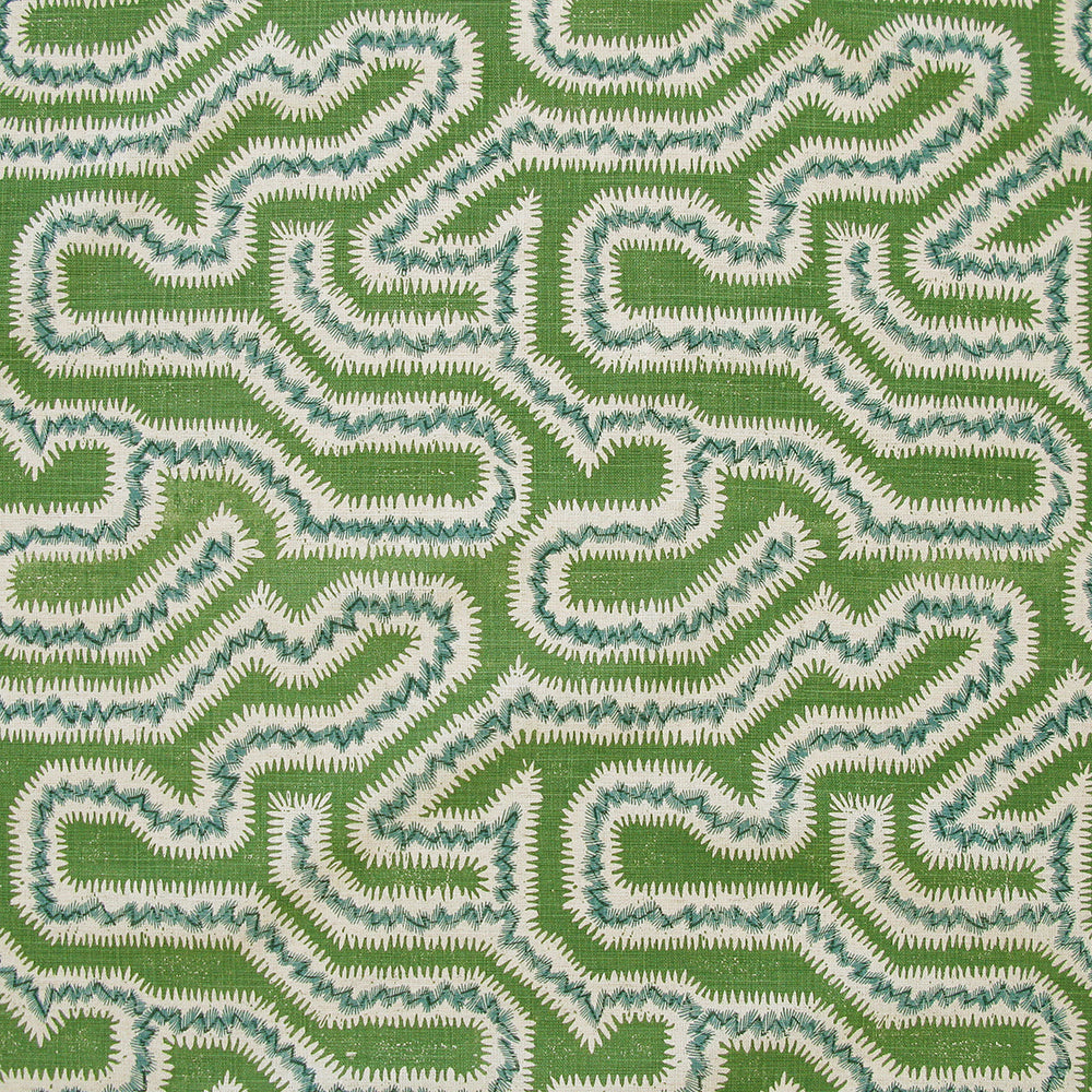 Detail of fabric in a dense meandering print in white, blue and navy on a green field.