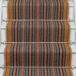 Striped flatweave runner in orange black red on white staircase