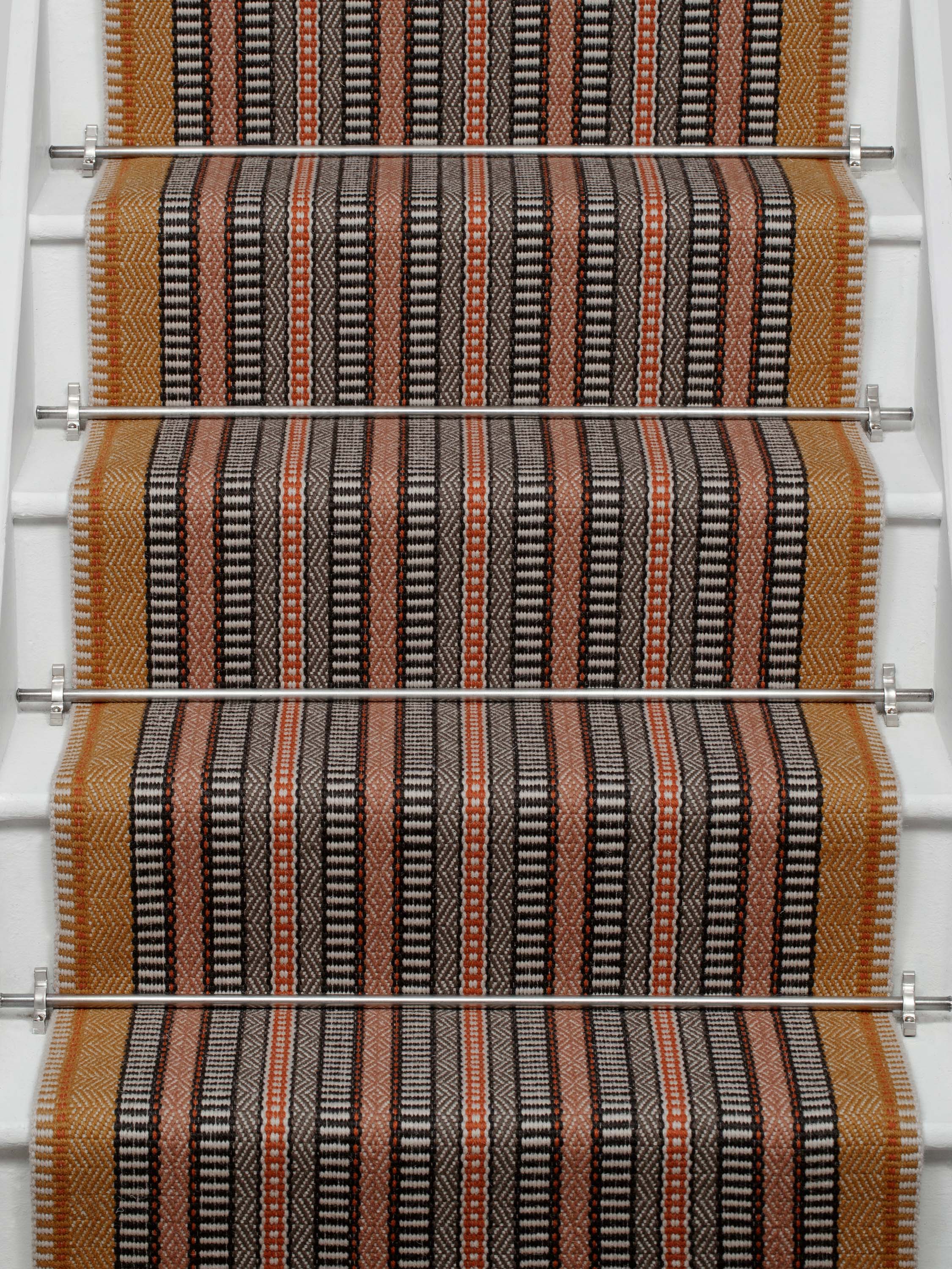 Striped flatweave runner in orange black red on white staircase