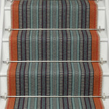 Striped flatweave runner in orange black blue on white staircase