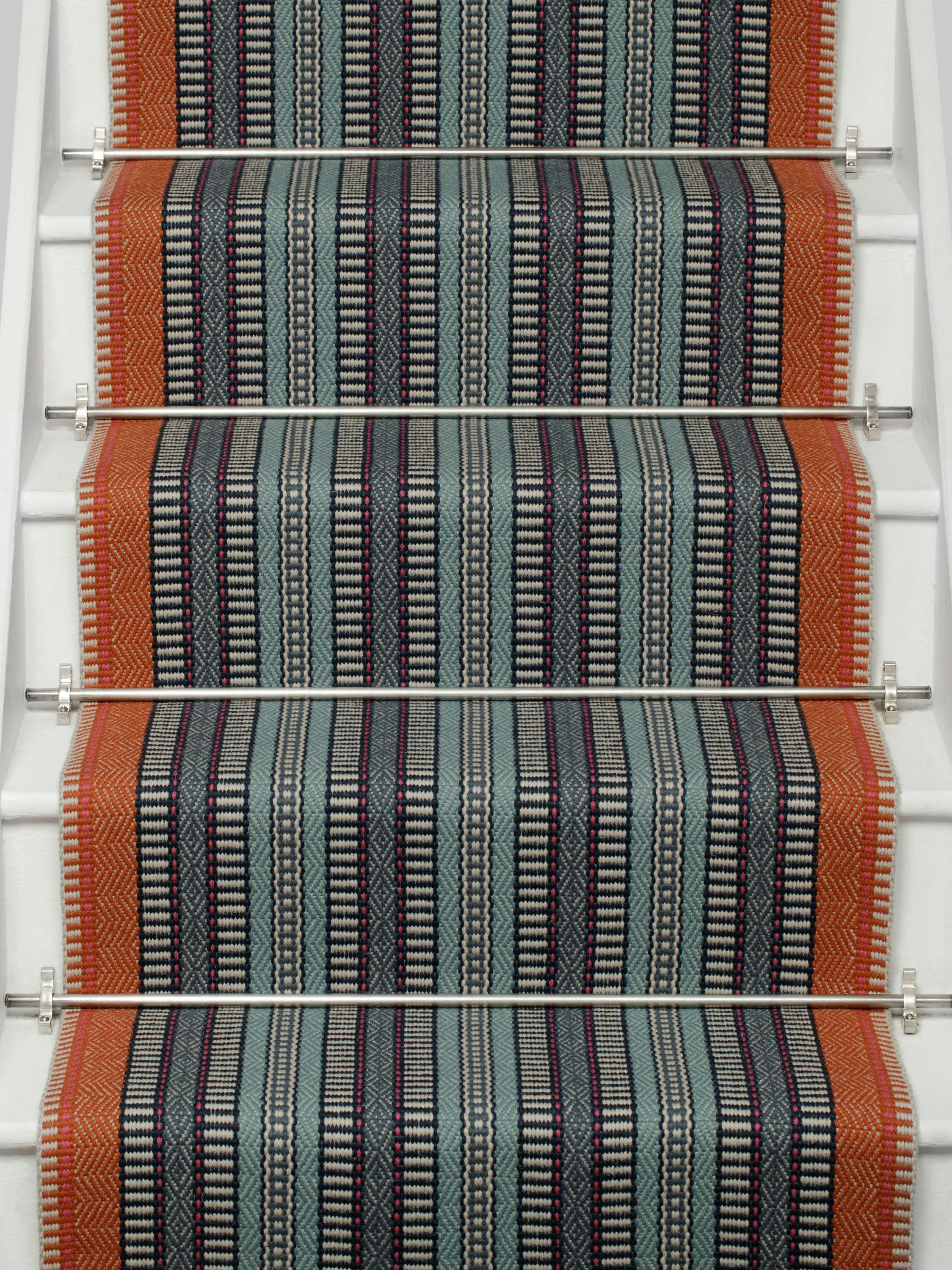 Striped flatweave runner in orange black blue on white staircase