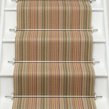 Striped flatweave runner in tan pink green blue on white staircase