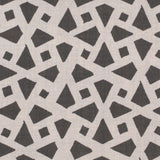 Detail of fabric in a geometric lattice print in charcoal on a greige field.