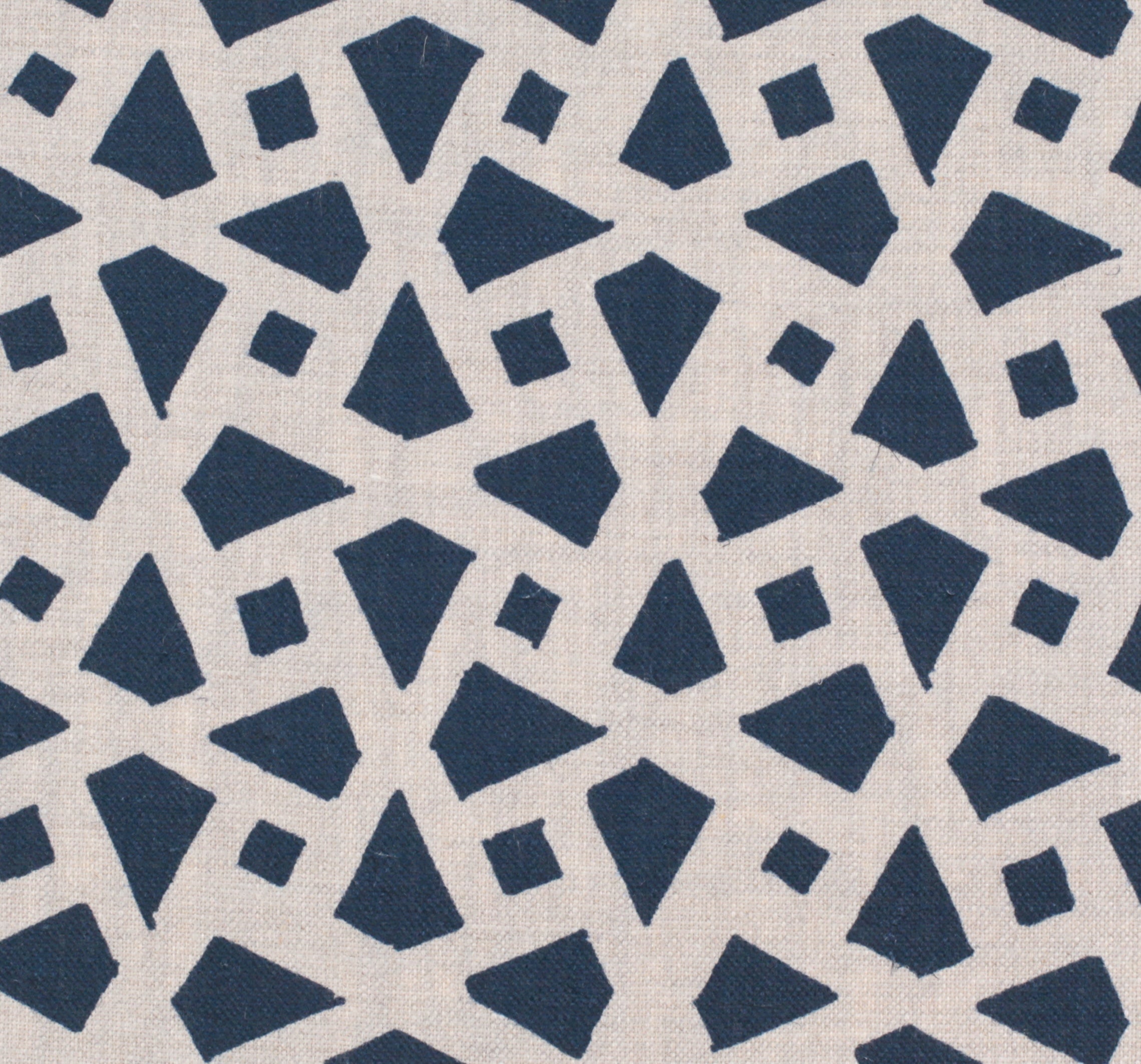 Detail of fabric in a geometric lattice print in navy on a cream field.