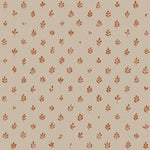 Detail of fabric in a repeating leaf print in burnt orange on a cream field.