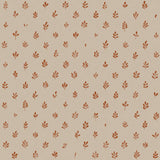 Detail of fabric in a repeating leaf print in burnt orange on a cream field.