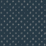 Detail of fabric in a repeating leaf print in cream on a navy field.