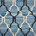 Detail of flatwoven rug with a black and white lattice design over a mottled blue ground