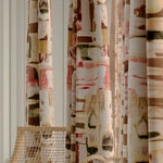 Close-up of a row of curtains in an abstract layered paint blotch print in shades of olive, cream and pink.