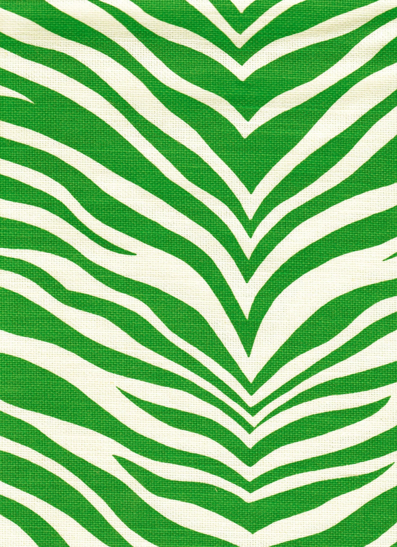 Detail of fabric in a zebra print in green on a white field.