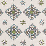 Detail of fabric in a diamond damask print in shades of green and blue on a cream field.