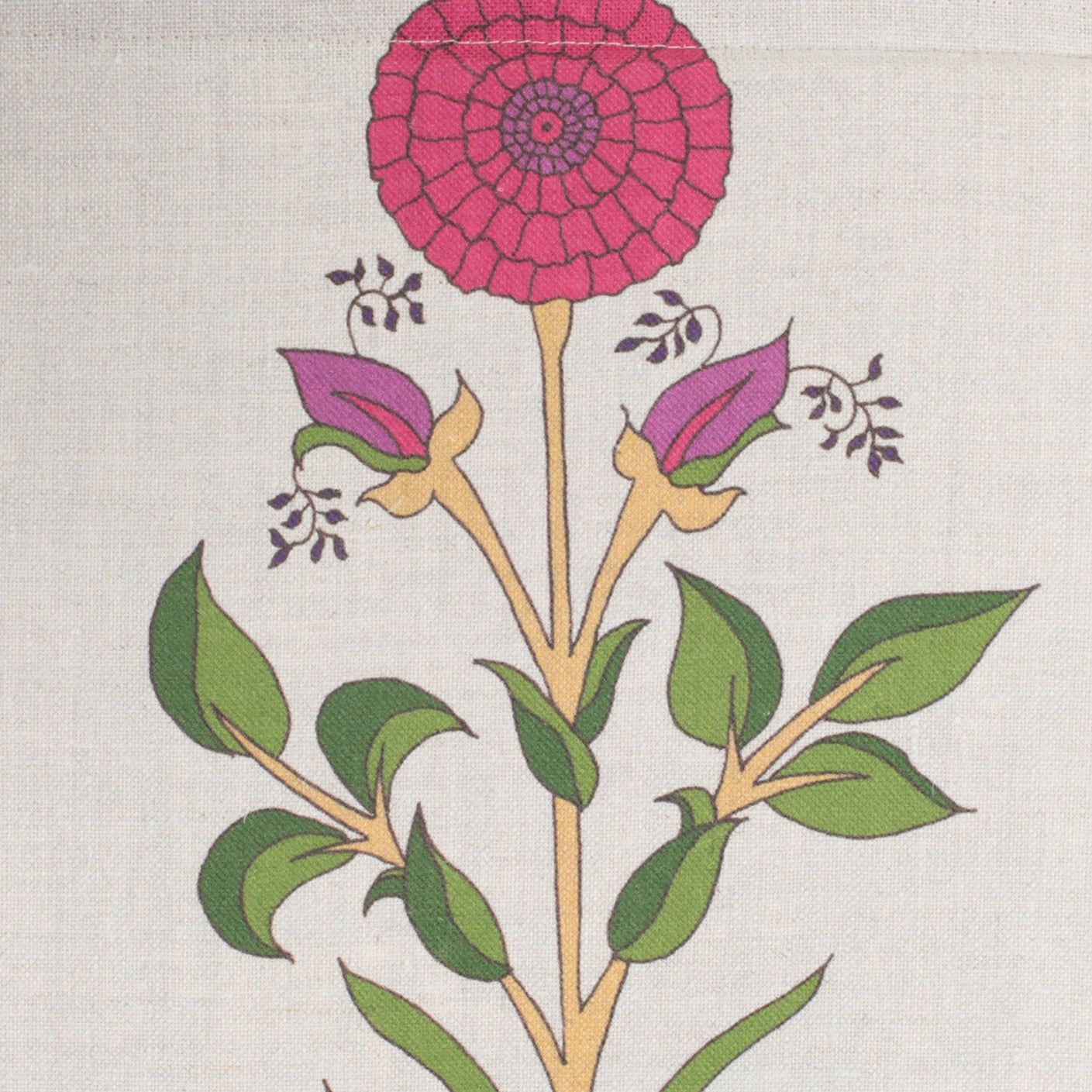 Detail of fabric in a large-scale marigold print in red, purple and green on a cream field.