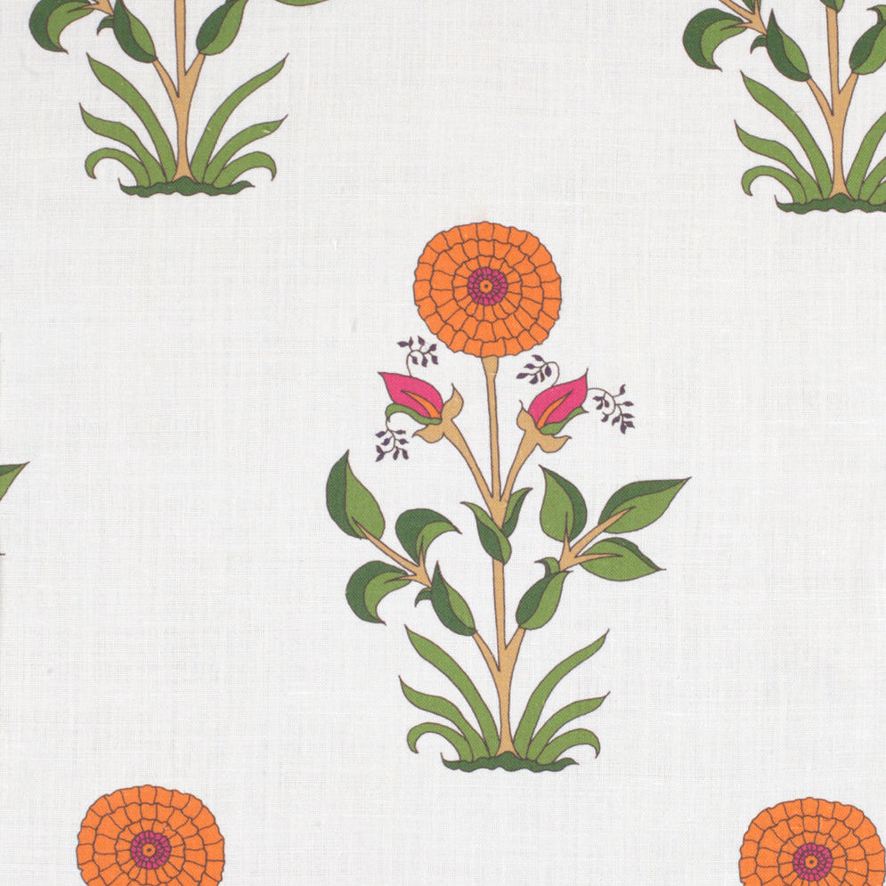 Detail of fabric in a large-scale marigold print in orange, pink and green on a white field.