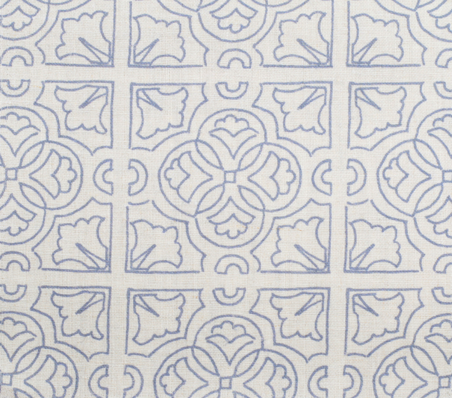 Detail of fabric in a damask lattice print in blue on a cream field.