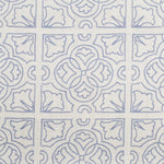 Detail of fabric in a damask lattice print in blue on a cream field.