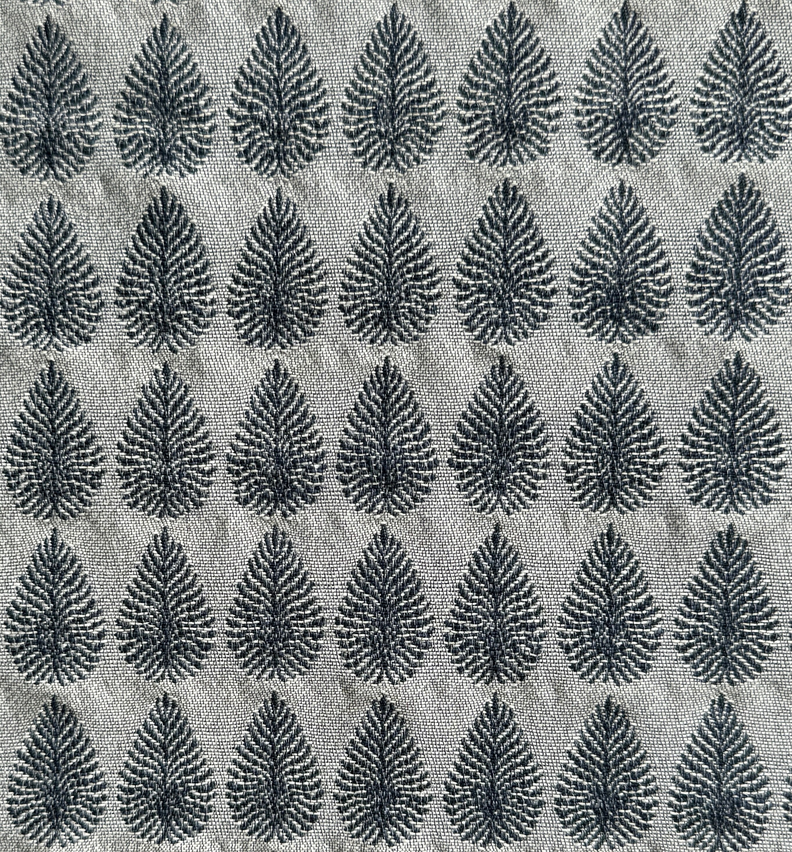 Detail of fabric woven in a repeating leaf print in shades of navy and gray.