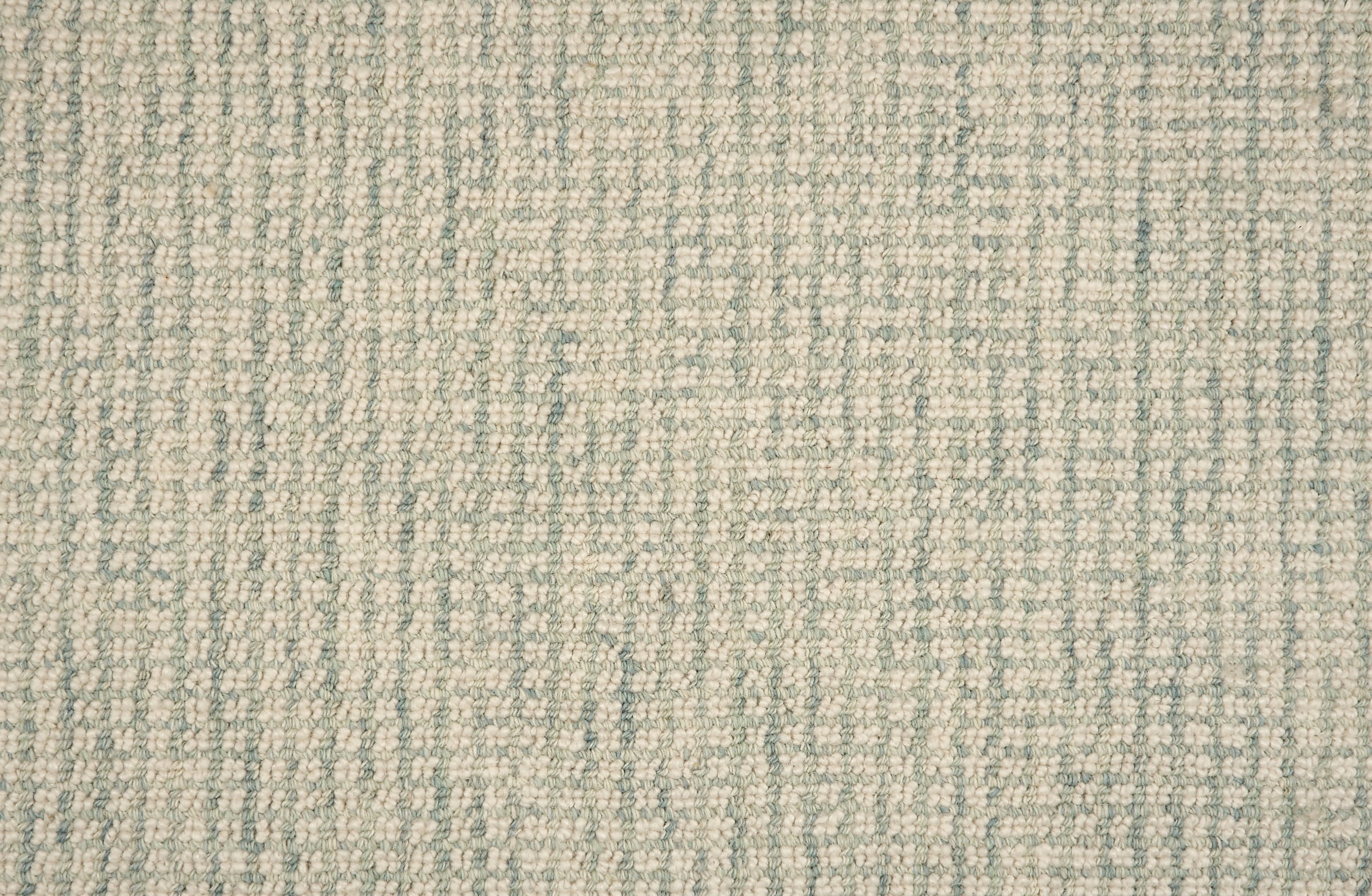 Broadloom carpet in a textural checkered pattern in ivory and light green. 