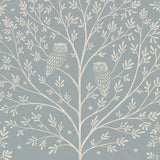 Detail of wallpaper in a repeating owl and tree print in cream on a light blue field.