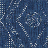 Detail of fabric in a dotted geometric print in white on an indigo field.