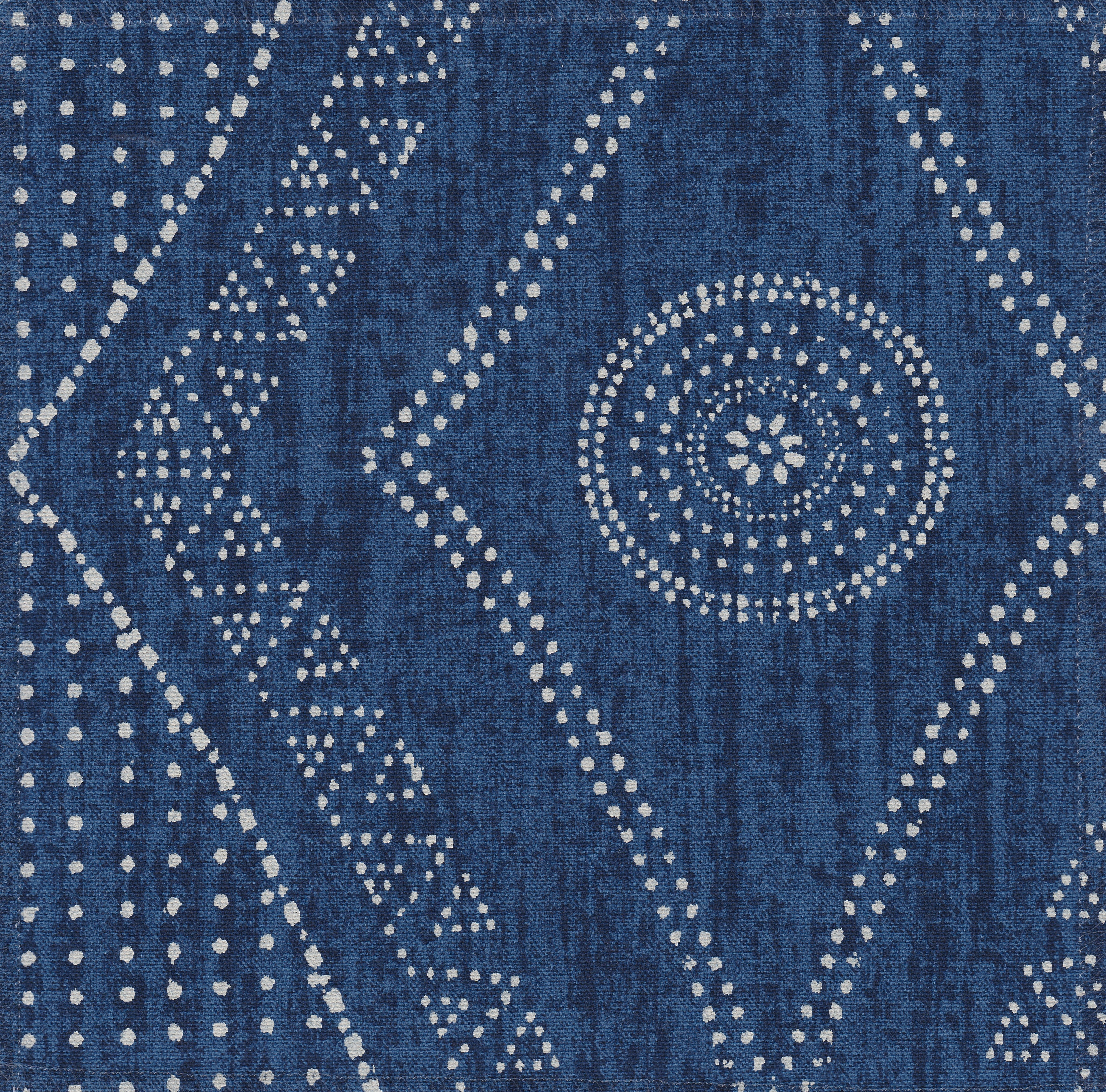 Detail of fabric in a dotted geometric print in white on an indigo field.