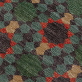 Close-up of a patterned rug with green, red, and beige colors.