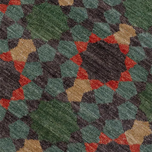 Close-up of a patterned rug with green, red, and beige colors.