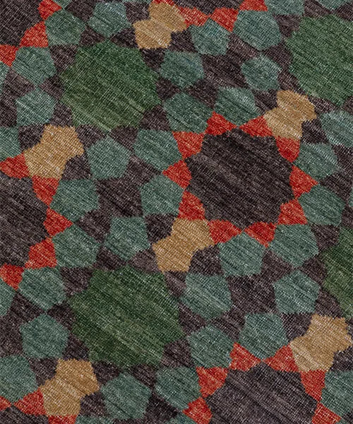 Close-up of a patterned rug with green, red, and beige colors.