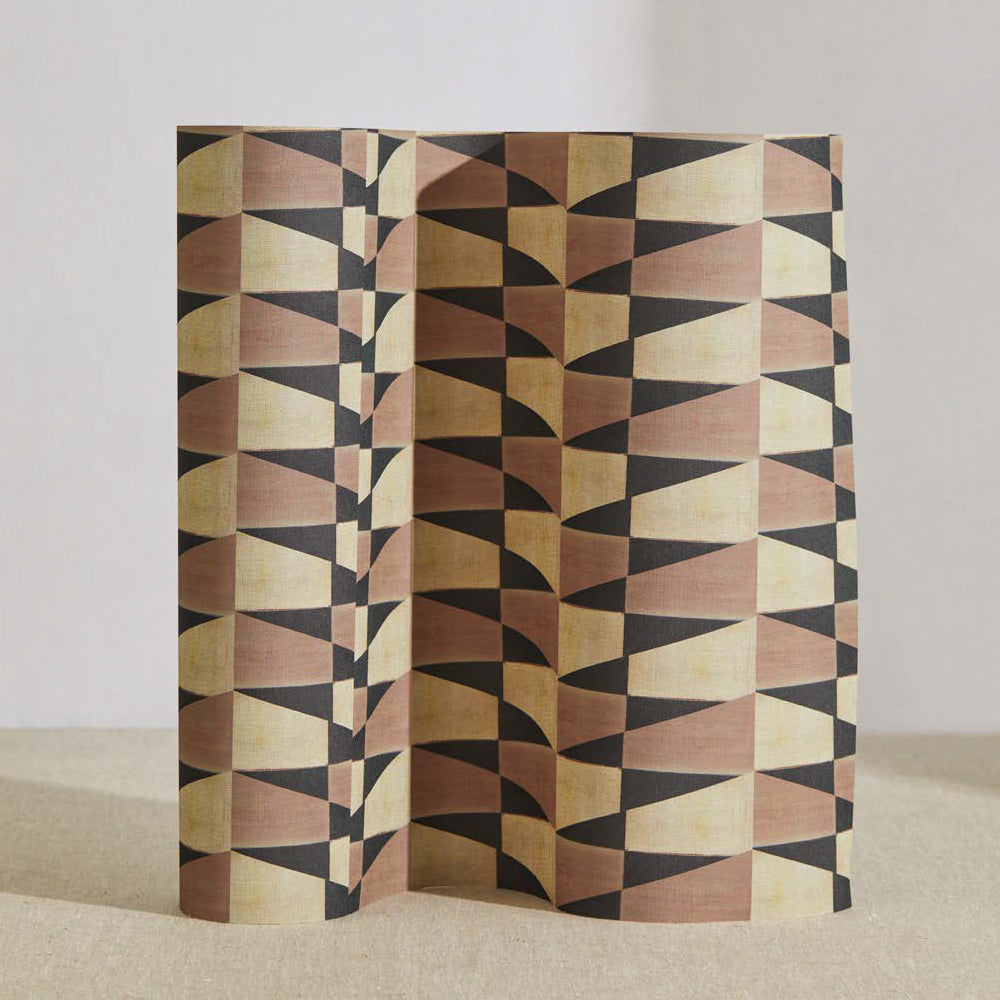 A curved partition stands on the ground, covered in a repeating triangle print in black, brown and gold.