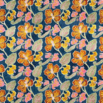 Detail of fabric in a flower and leaf print in shades of orange, pink and green on a navy field.