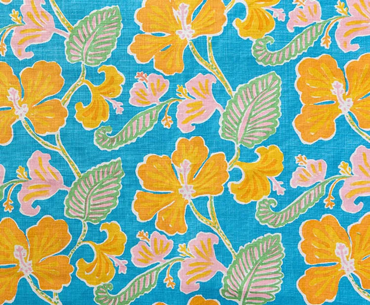 Detail of fabric in a flower and leaf print in shades of orange, pink and green on a blue field.