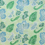 Detail of fabric in a flower and leaf print in shades of blue and green on a light green field.