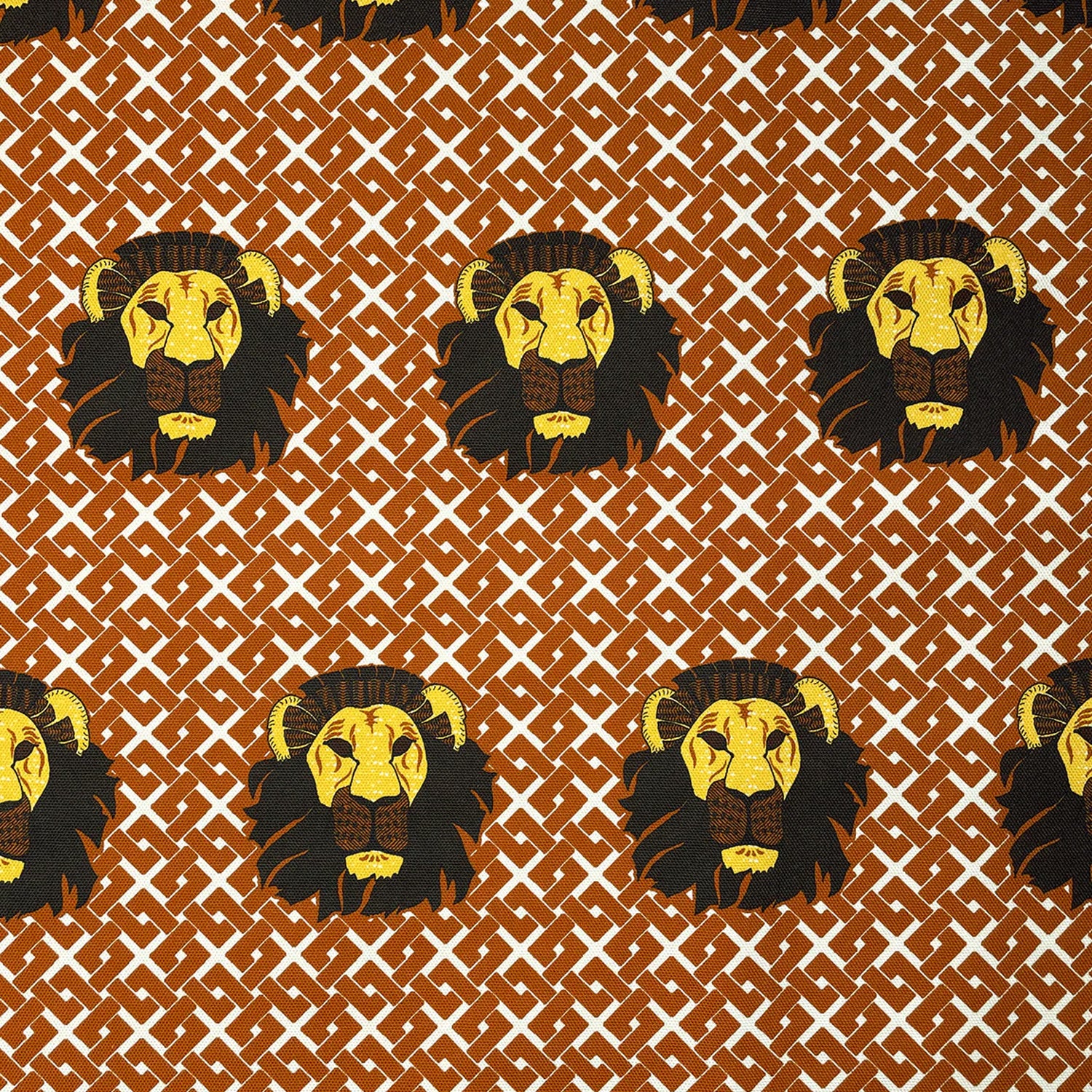 Detail of fabric in a repeating lion face print on a geometric field in shades of red, brown and yellow.