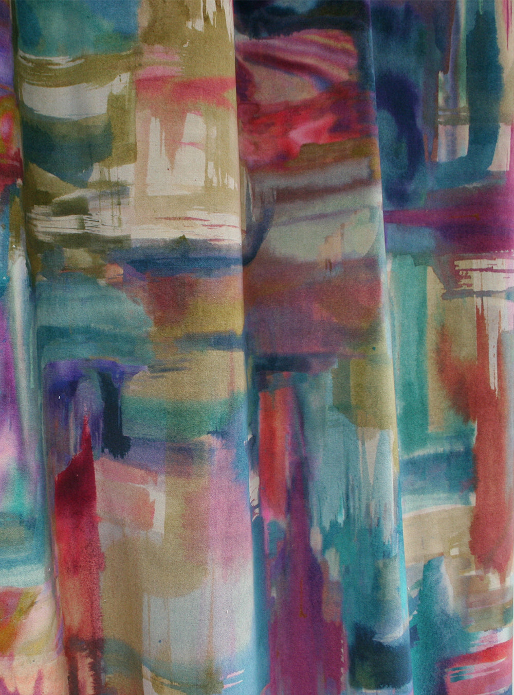 Draped fabric yardage in an abstract painterly print in shades of pink, turquoise and yellow.