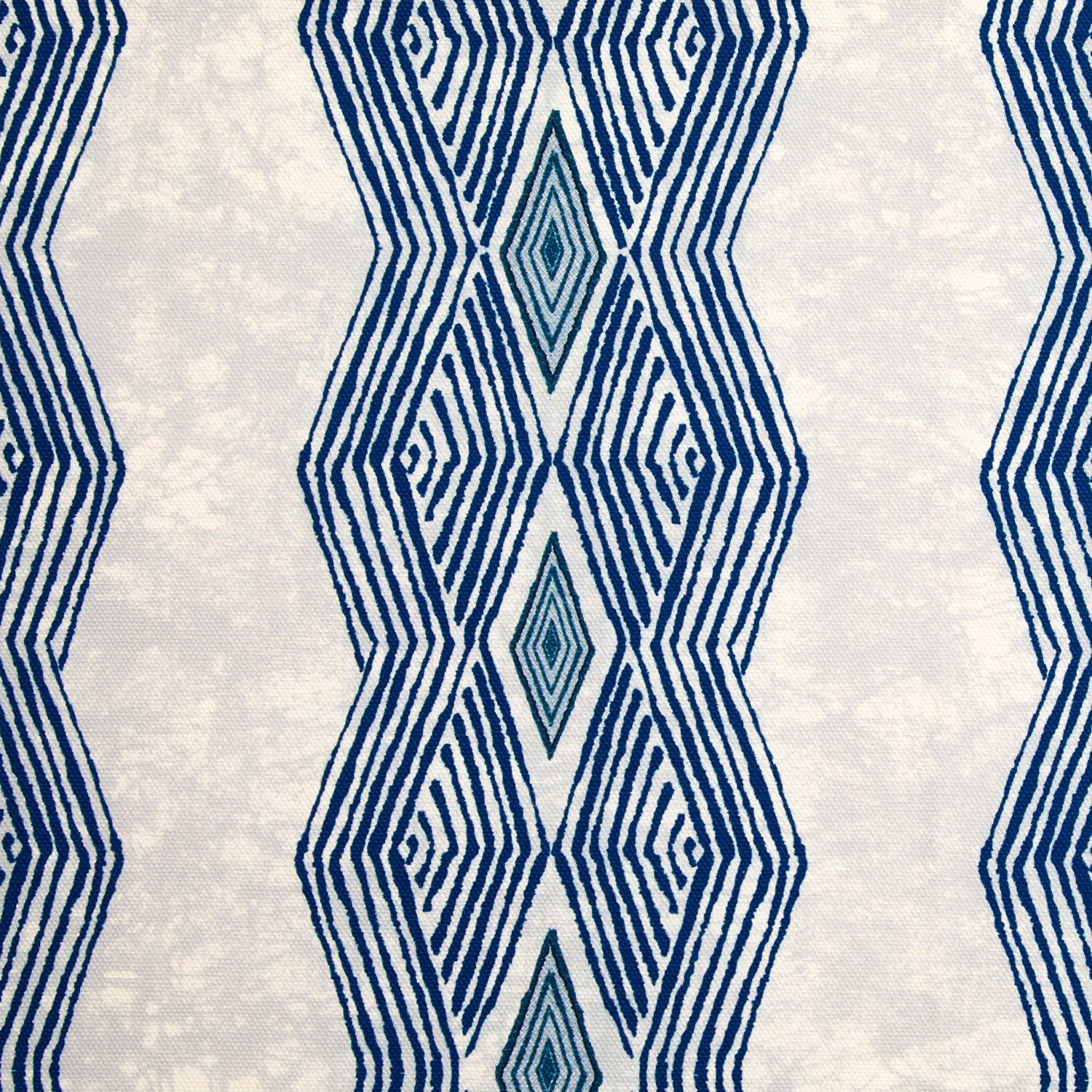 Detail of fabric in an intricate diamond stripe print in blue and navy on a cream field.