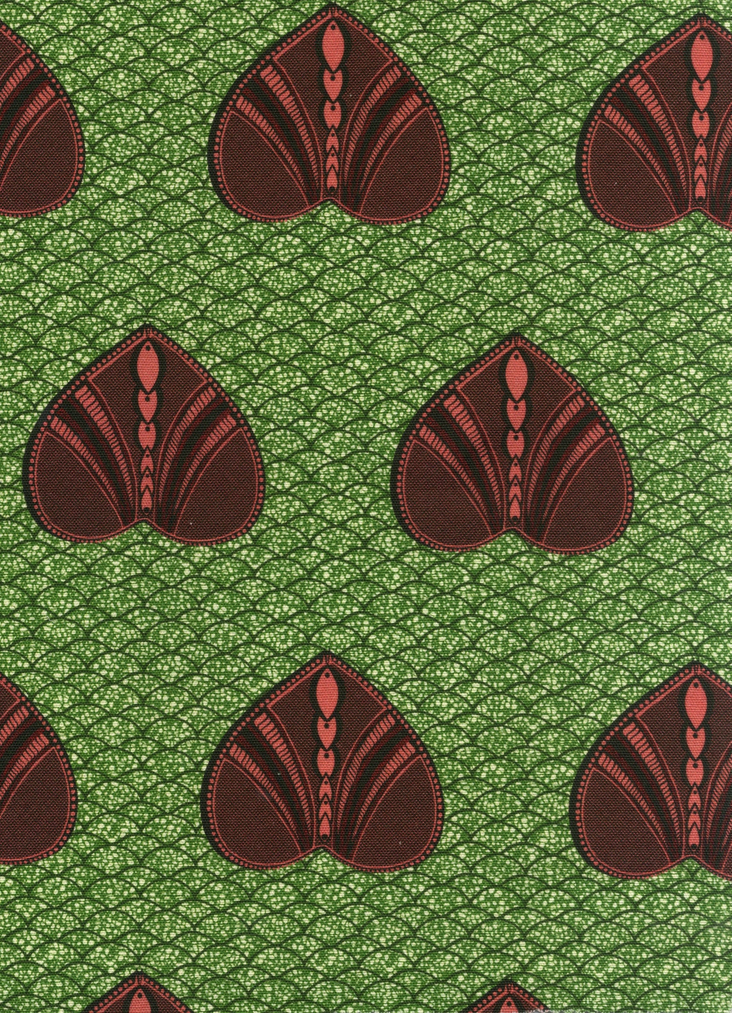 Detail of fabric in a geometric heart print in maroon and black on a green field.