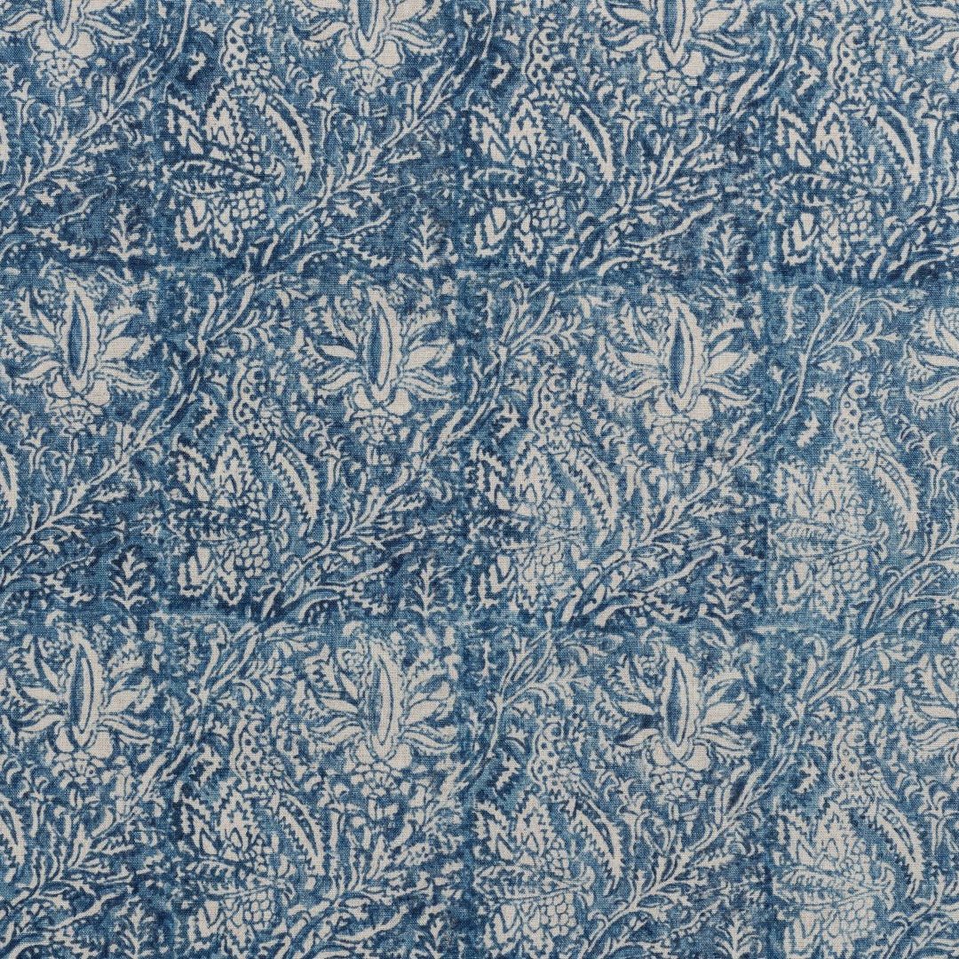 Detail of fabric in a paisley block print in cream on a navy field.