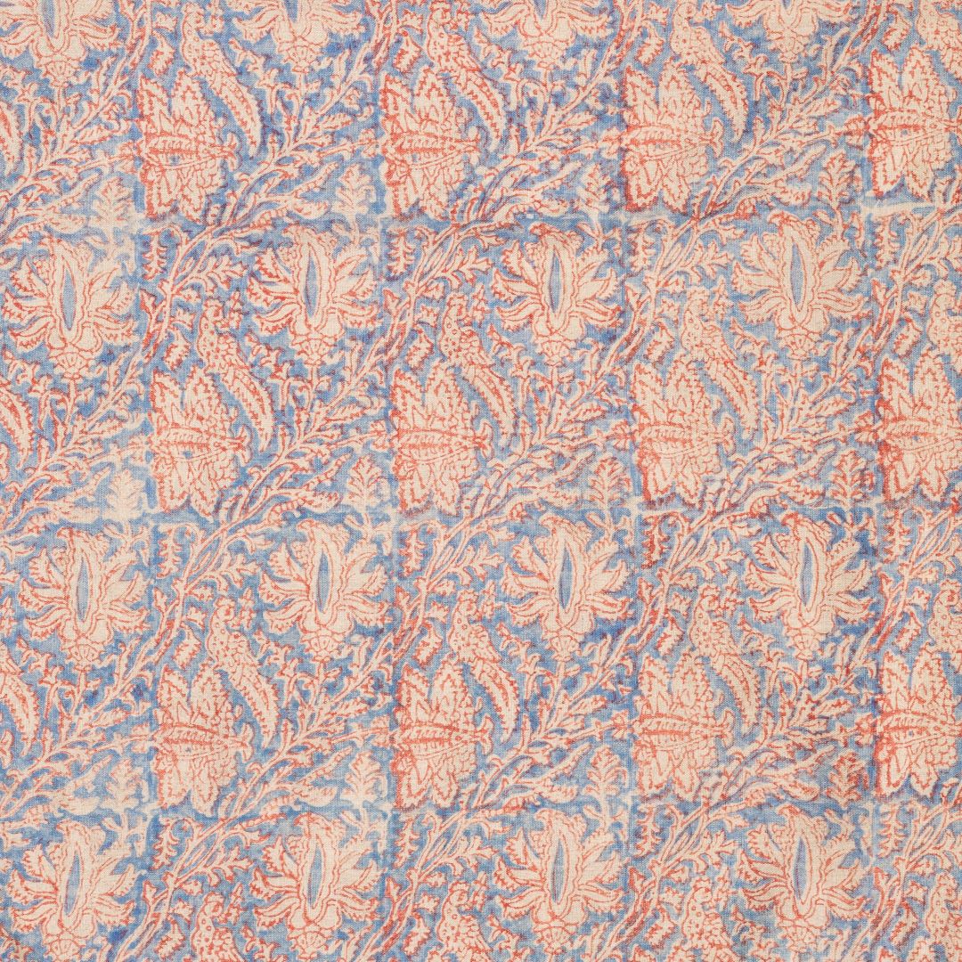 Detail of fabric in a paisley block print in red and cream on a navy field.