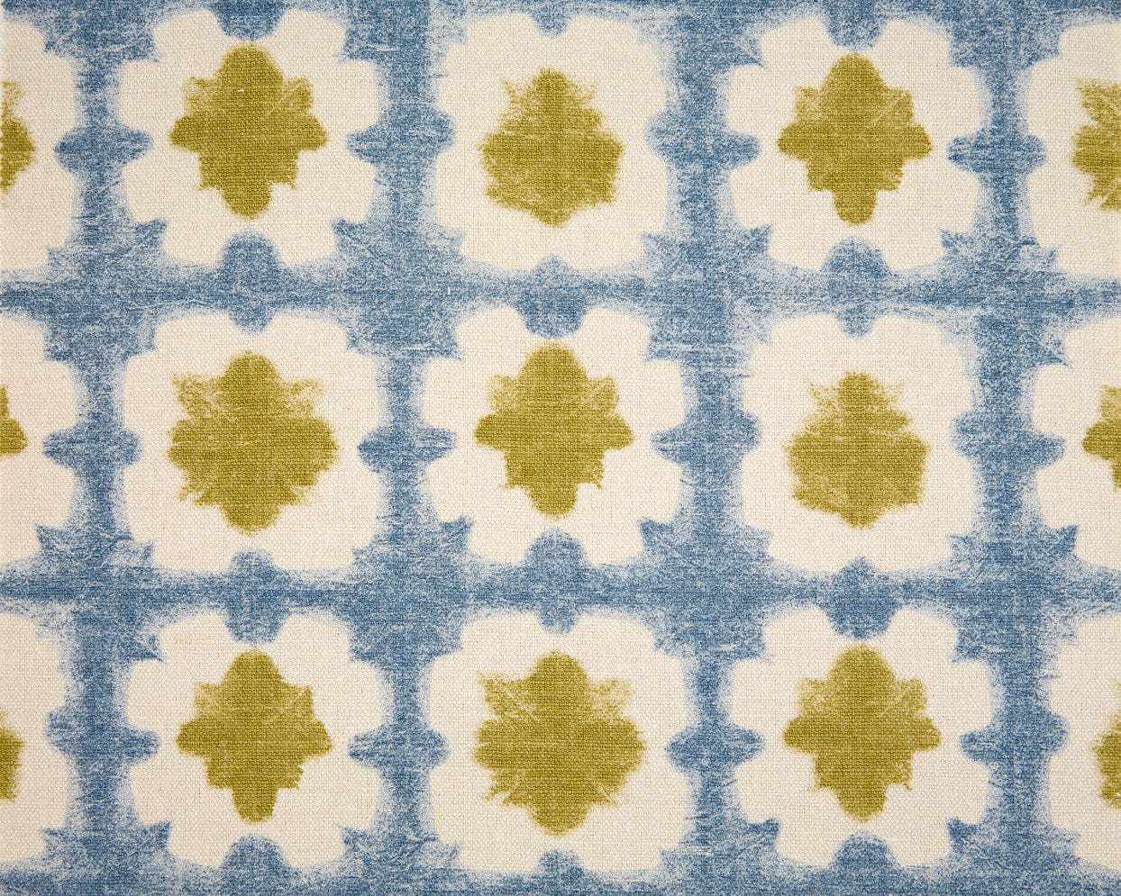 Detail of fabric in a dyed grid print in olive and blue on a cream field.