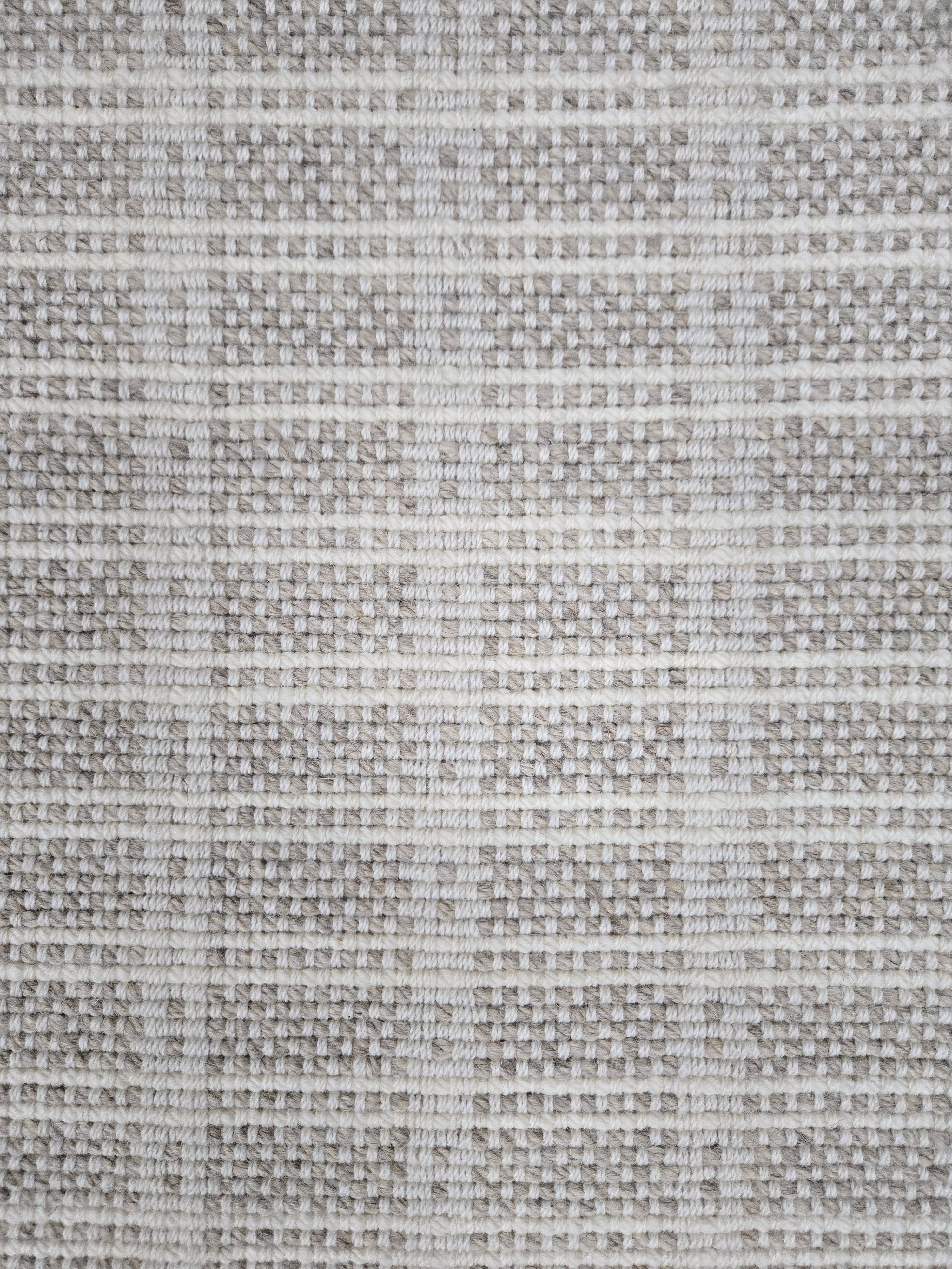 Broadloom carpet in slim plaid pattern in cream and pale grey.