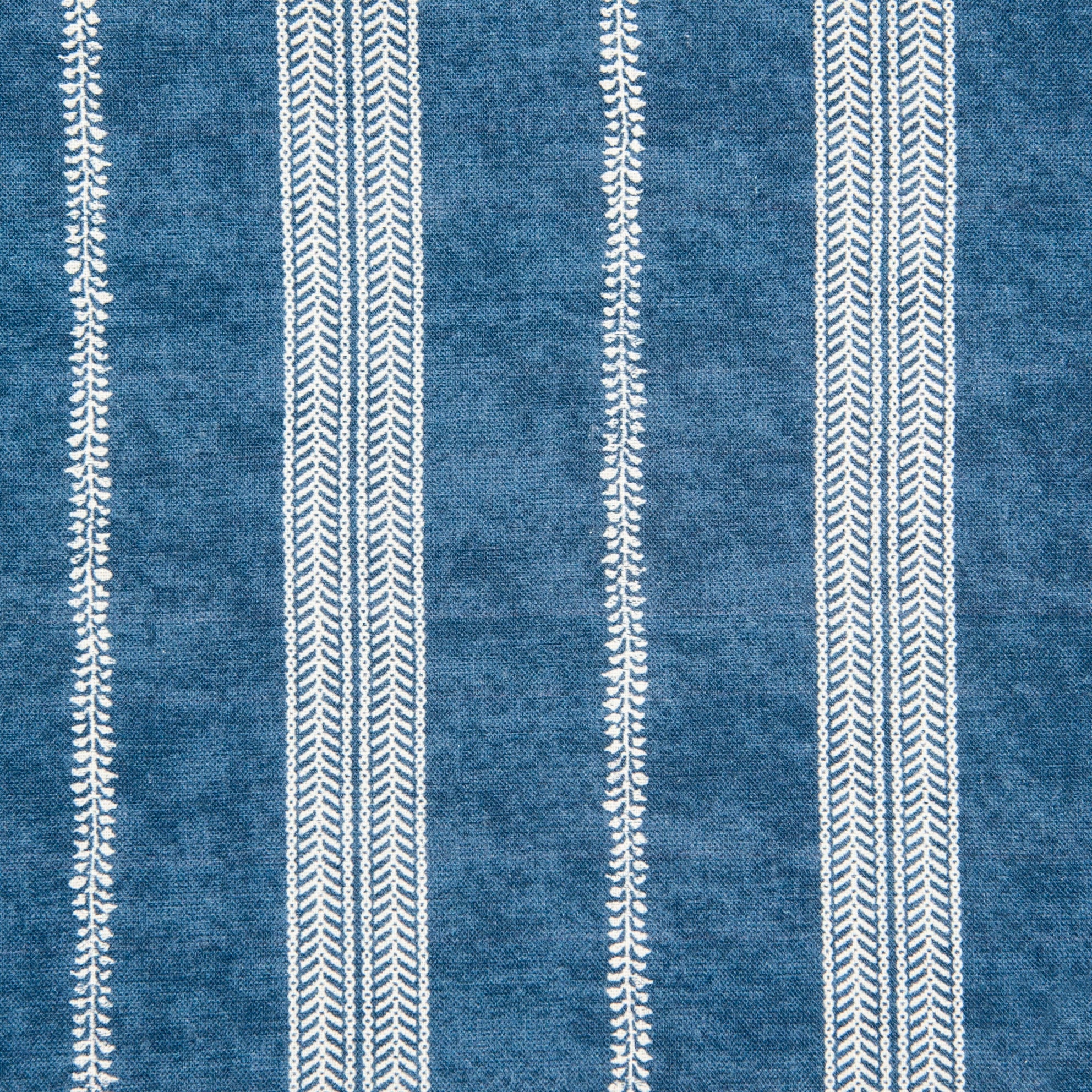 Detail of fabric in a small-scale botanical stripe print in white on an indigo field.