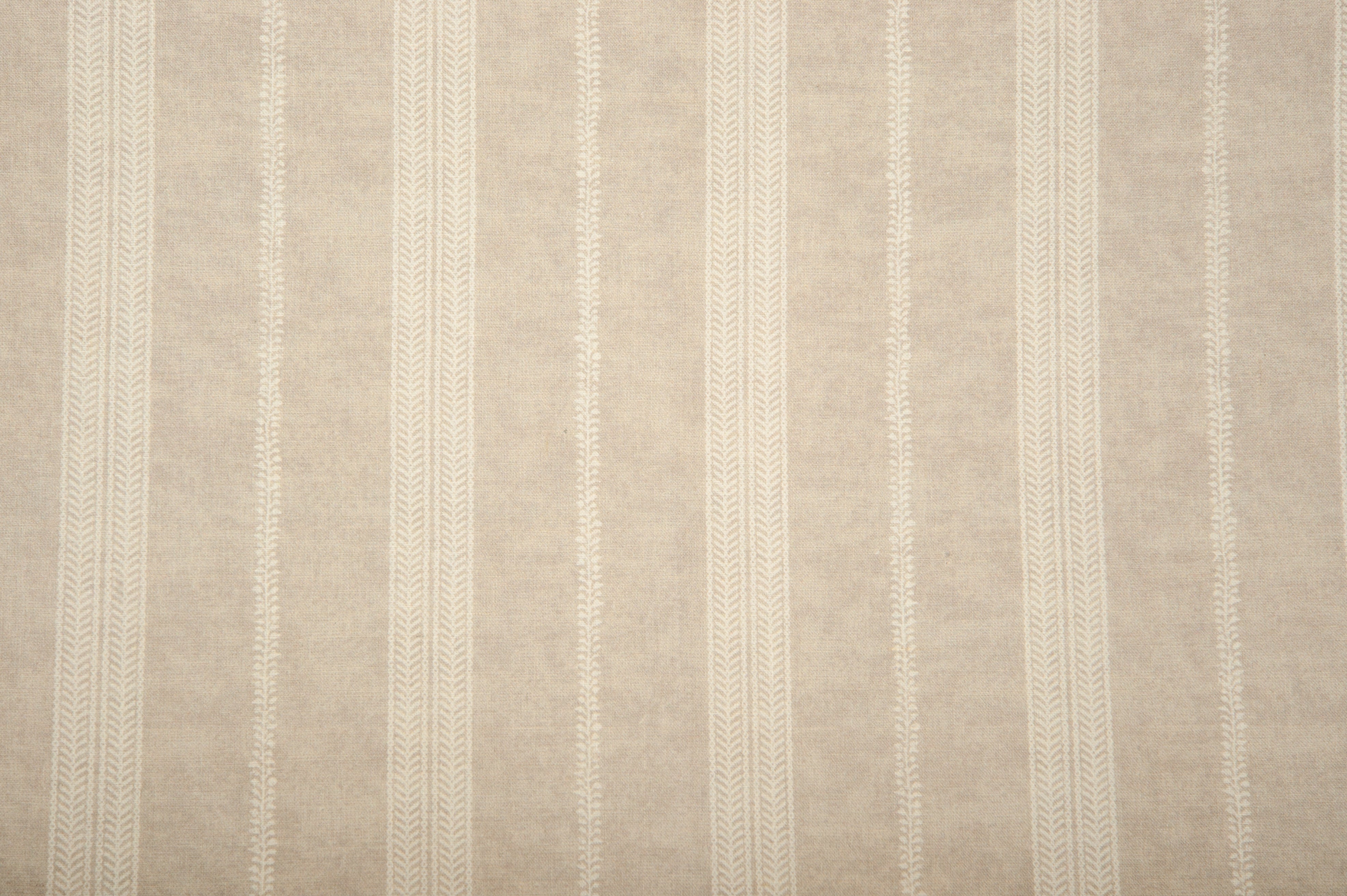 Detail of fabric in a small-scale botanical stripe print in cream on a tan field.