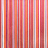 Detail of outdoor fabric in an irregular stripe print in shades of red, orange and white.