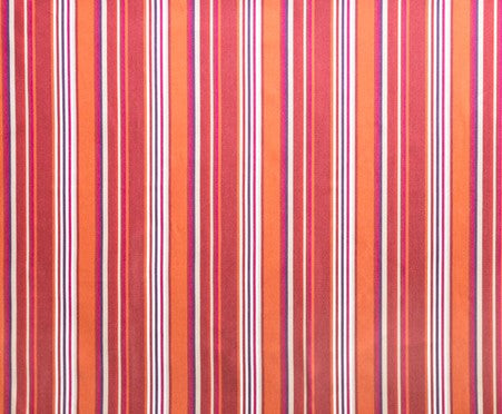 Detail of outdoor fabric in an irregular stripe print in shades of red, orange and white.