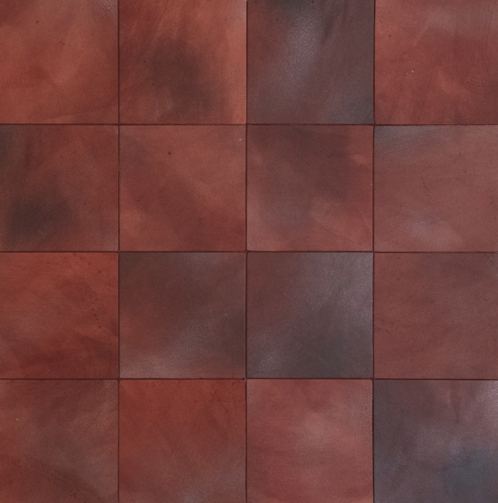 Detail of leather wall tiles in a square pattern in mottled oxblood and gray.