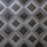 Detail of wallpaper in a diamond lattice print in shades of gray and charcoal.